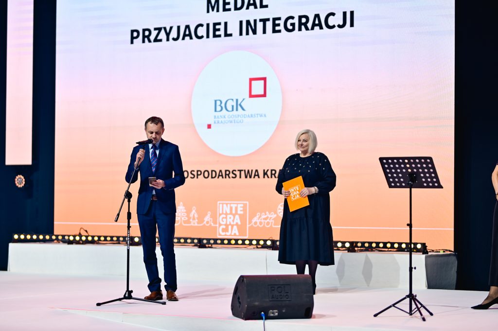 Na scenie 28. Wielkiej Gali Integracji Tomasz Robaczyński, który z rąk Ewy Pawłowskiej w imieniu banku BGK odbiera Medal Przyjaciela Integracji.